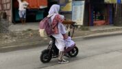 anak sekolah mengendarai sepeda listrik